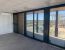 Vista interior de oficina modular prefabricada exterior con grandes ventanales y doble altura