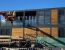 Oficina prefabricada exterior de doble altura con terraza y barandilla de vidrio estructural